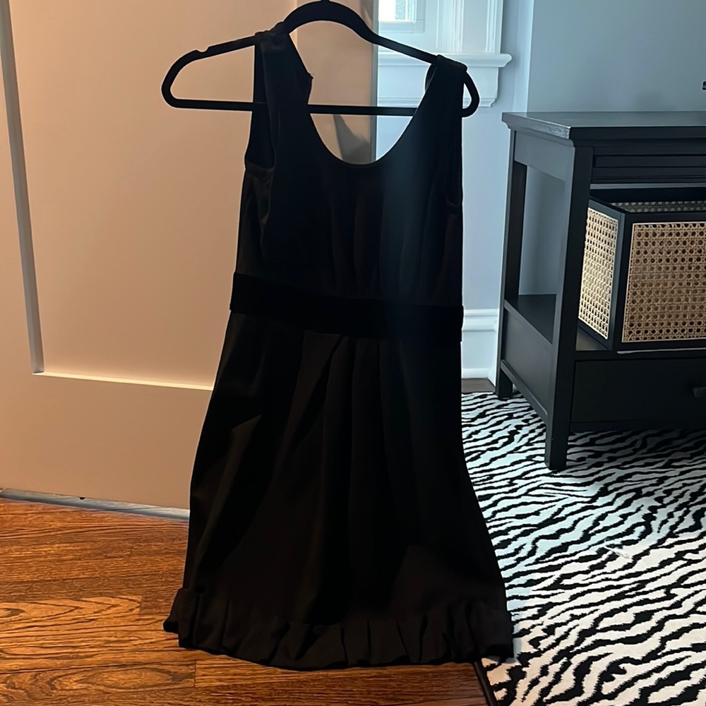 Black sleeveless dress with velvet detail and ruffled trim. Size 0-2